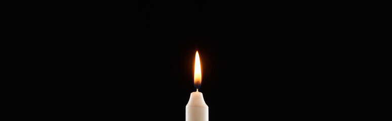 burning white candle glowing isolated on black, panoramic shot