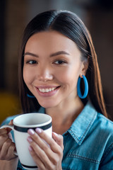 Portrait of a delighted Asian woman smiling