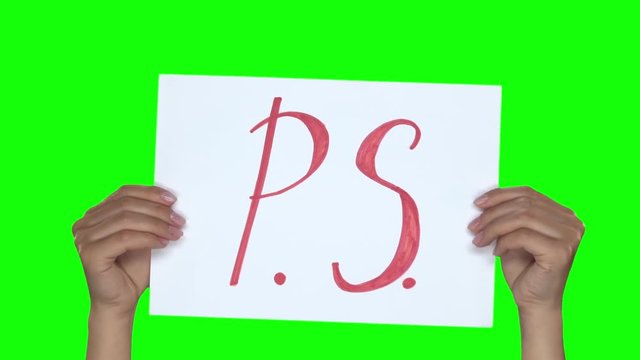 Hands showing paper with inscription P.S.. Green screen. Close. Slow.