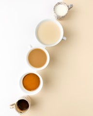 Different coffee beverages on white beige bacground