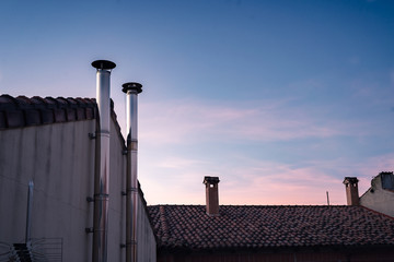 Chimmeys and rooftops with sunset sky. Mountain village.