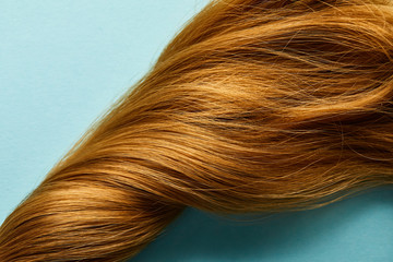 Top view of twisted brown hair on blue background