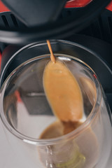 Pouring espresso coffee on a drinking glass