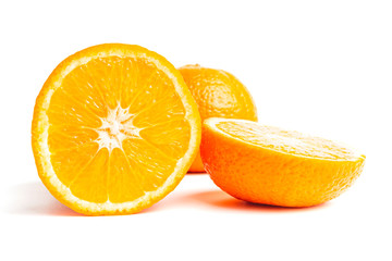 Sliced round halves of orange fruit and whole citrus isolated on white background