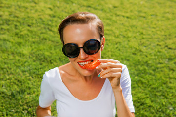 Beautiful caucasian woman eating salad over green natural background
