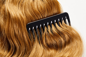 Obraz premium Top view of comb on brown hair isolated on white