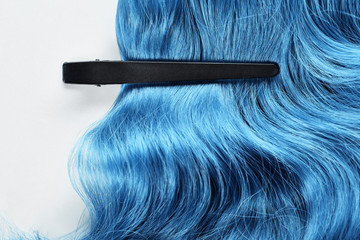 Naklejka premium Top view of clamp on blue hair on white background