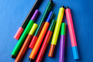 Multi colored felt pens with wrong color caps at blue background