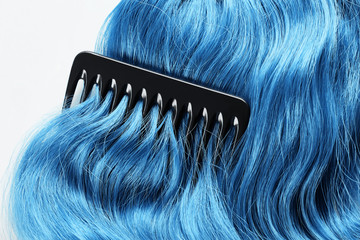 Obraz premium Top view of comb on colored blue hair isolated on white