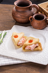 pancakes with cream cheese and smoked salmon on wooden table