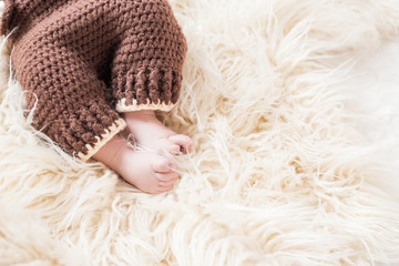 legs of a newborn baby on a white wooly background