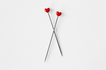 Two heart shaped pins on white background - Concept of love and relationship