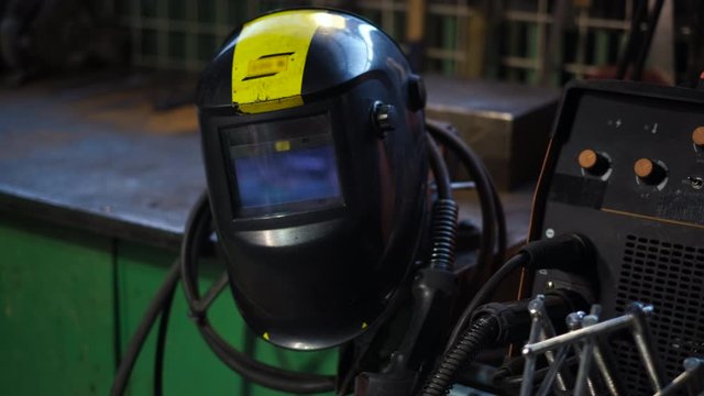 Close-up of welding equipment. Protective mask and gas cylinders in workshop