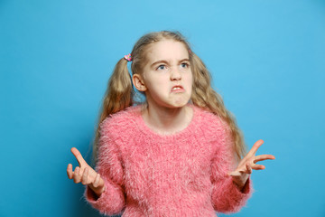The emotions of a child. Small girl angry isolated. Beautiful little girl get angry on a blue...
