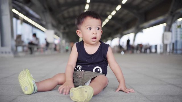 Adorable todder baby boy sitting on train station people transport background recreation concept