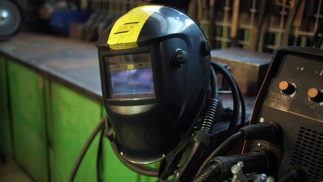 Close-up of welding equipment. Protective mask and gas cylinders in workshop