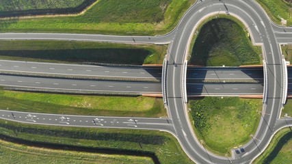 Aerial view on top Travel cars interchange in the form of a ring on the highway. Exit from the motorway view from the top.