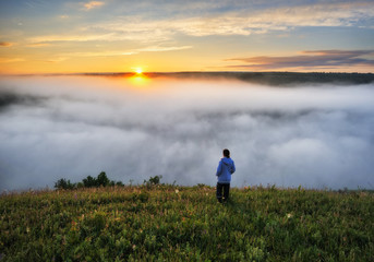 tourist over the fog. morning fog in the canyon of the river. woman enjoys a beautiful view
