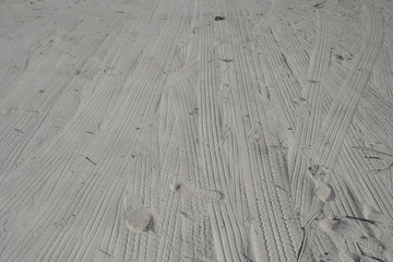 Car Tyre Tracks On The Beach Sand In Perspective. Car Tire Prints On A Road Leading To Beach Covered In Sand. Wheel Tracks On The Soil. Wheel Track On Muddy Ground. Off Road 4X4 Wheel Tracks Motoring.