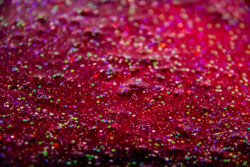 A glitter in the red liquid. Very nice background with colorful glitter.