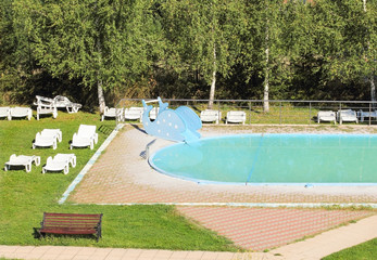 Swimming pool with the plastik sunbeds around it.