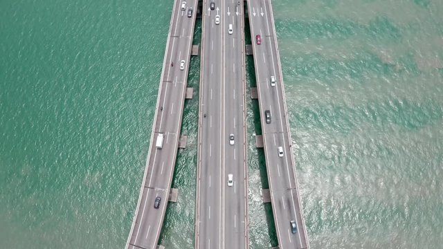 Aerial view of Penang Bridge Malaysia from the island to the land, drone tilt-up reveal shot