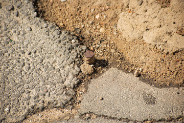 A piece of reinforcement stick in the asphalt