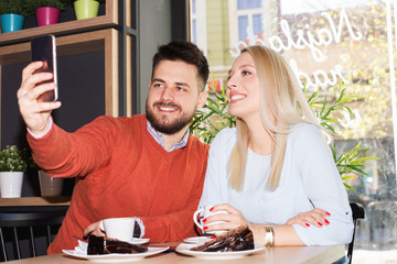 Beautiful loving couple sitting in a cafe enjoying in coffee and conversation. Love, romance, dating