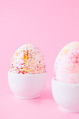 Two easter eggs decorated with classic blue watercolour aquarelle in carton, minimalism style on plain pink background. Easter holiday decorations with copy space