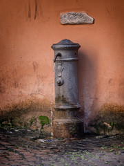 Old fashioned water drinking post in Rome, Italy