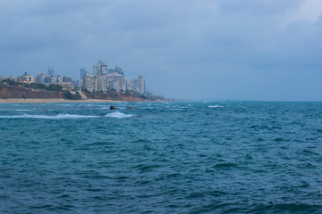 Middle East Israeli Tel Aviv suburban Mediterranean district waterfront port city soft focus buildings in fog of stormy weather time and sea wavy waters environment, copy space
