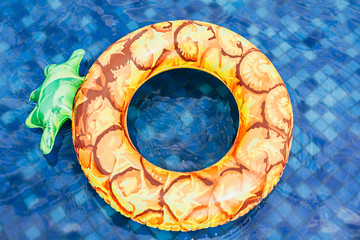 Pineapple pool float, ring floating in a refreshing blue swimming pool