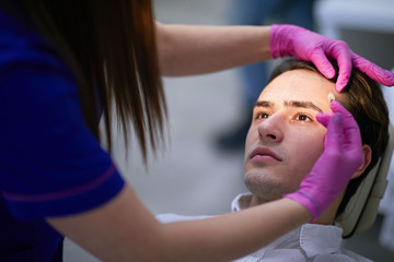 Nurse inserting anti aging substance beneath the forehead skin
