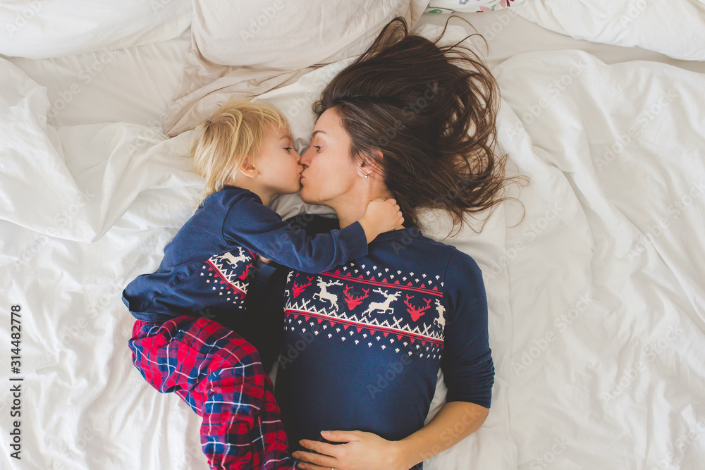 Poster Nice sleepie morning in bed, mom and toddler child, boy, playing, kissing