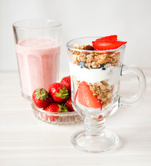 Milkshake glass of fresh strawberries. Berry granola, yogurt dessert. Healthy eating, healthy breakfast concept