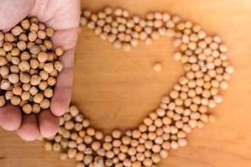 chickpeas laid out in the shape of a heart and chickpeas in the hand