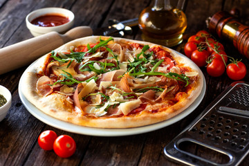 Pizza dish, rolling pin, grater, cherry tomatoes, pepper mill, oil and pizza sauce