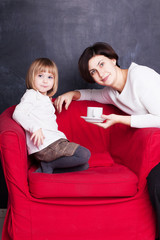 Obraz premium mom gives her baby a cup of tea