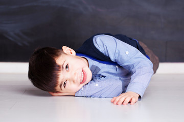 Happy boy lies on the floor and enjoys life