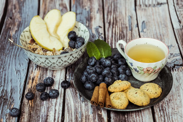 Petit déjeuner sain thé avec croissant biscuits cannelle muesli pommes et myrtilles