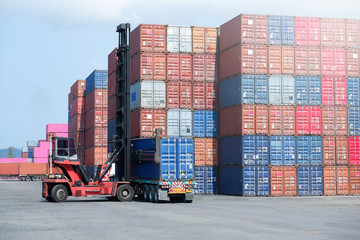 Container handlers are loading containers into trucks.