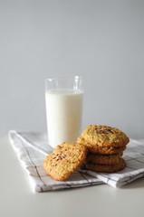 Stack of handmade oatmeal cookies with glass of milk