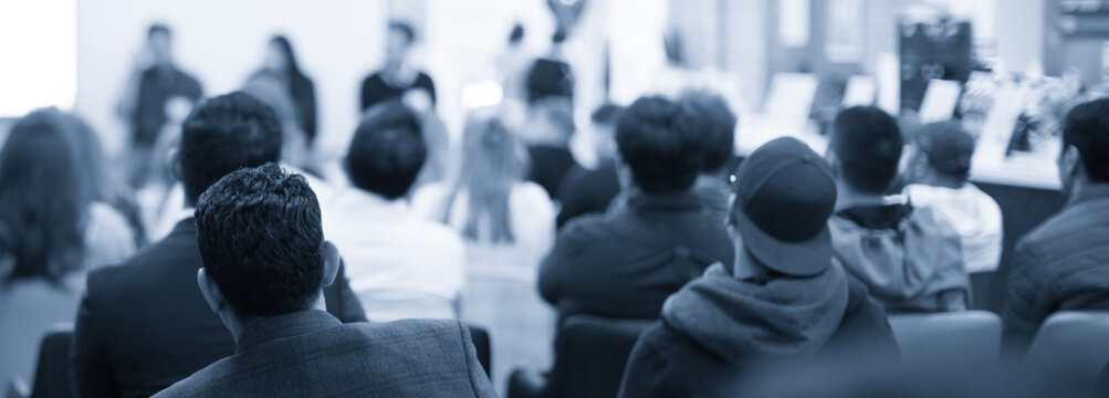 Corporate seminar for tech entrepreneurs in auditorium. Audience participants in development workshop. Executive manager giving speech at symposium. Business training at university lecture hall.