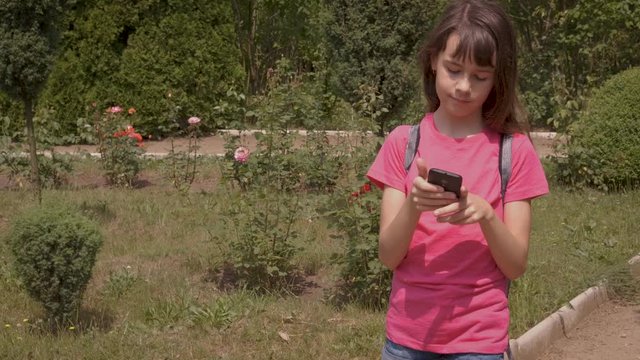 The child walks with a smartphone.