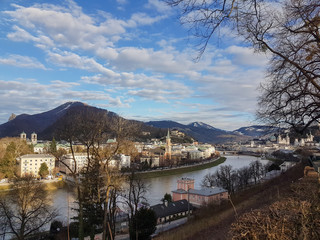 Panorama of Salzburg, Austria. River canal separates the town of Salzburg. Little town in Austria. Mountains in the background.