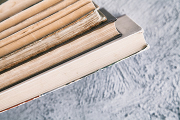 stack of old books on a gray textural background