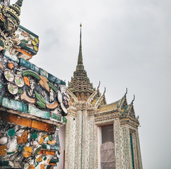 Fototapeta premium Close-up decoration ornament pattern details of famous buddhist stupa of Temple of Dawn, Wat Arun, Bangkok, Thailand. Showing glass and ceramics elements combination in Thai style on the pagoda base