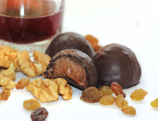 A close up view of chocolate candy intersection with raisins, walnuts and natural juice in the background.