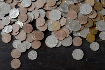 A pile of American cents on an old black wooden surface close-up. Money background