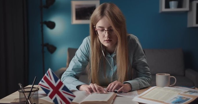 Attractive young lady reading english book indoors, studying foreign language